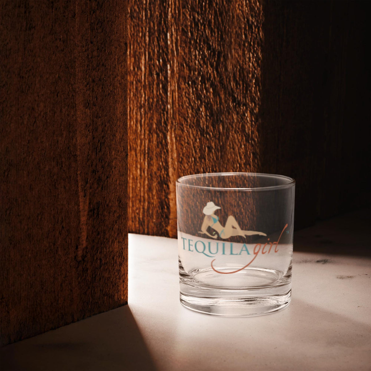 Empty Tequila Girl rocks glass in warm window light